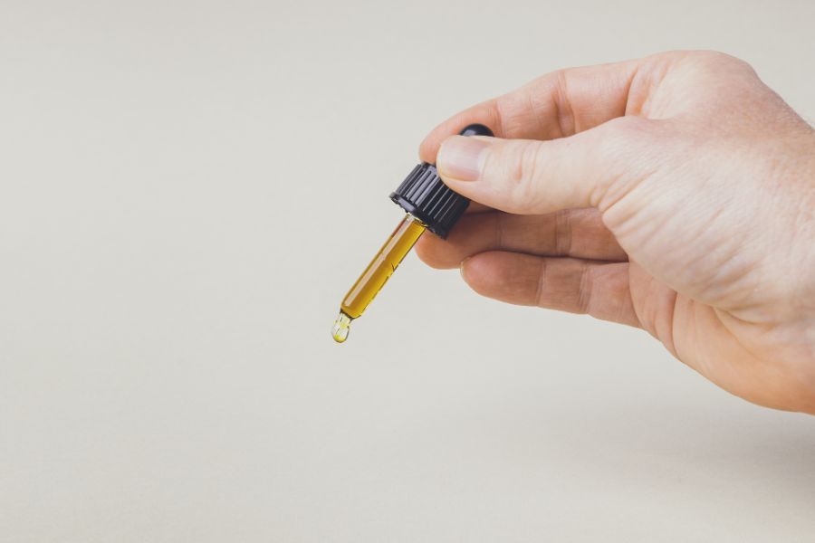 hand holding cbd dropper containing cbd oil