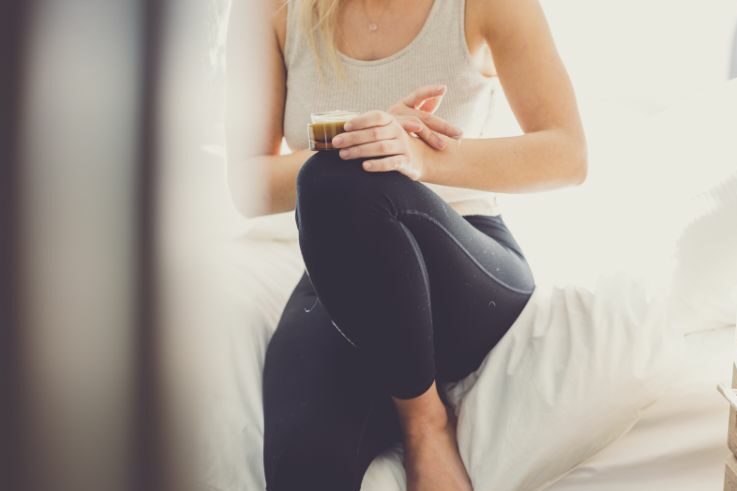 lady on bed applying CBD cream